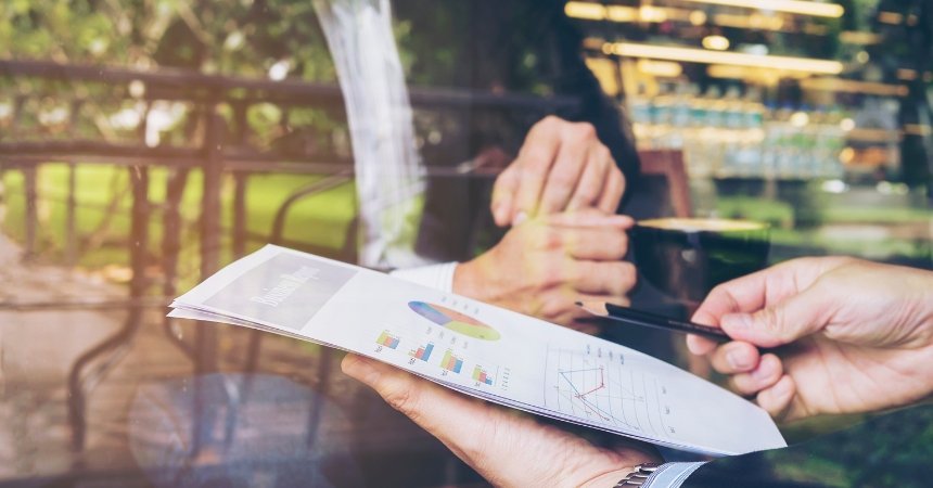 Disciplined investor reviewing property market charts and investment report during a strategy discussion