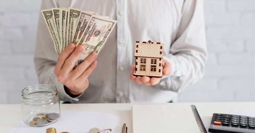 Person holding cash and house model representing Sydney residential property investment planning